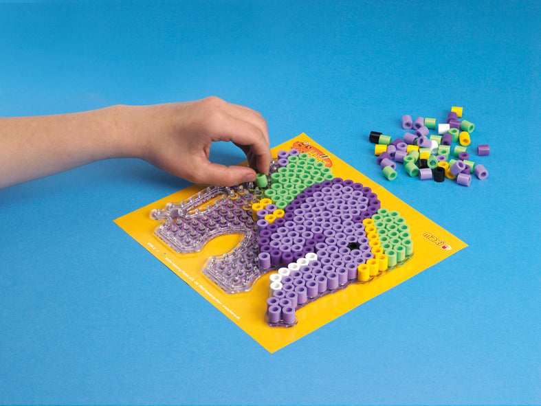 a child's hand placing beads on a elephant shaped puzzle